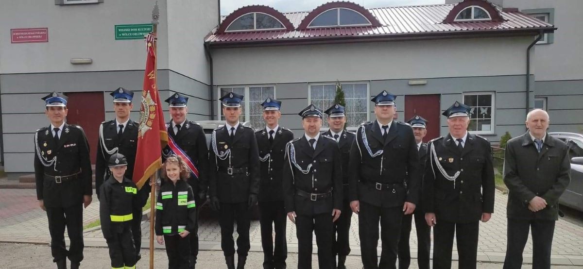 Strażacy z OSP Wólka Orłowska, sztandar trzymają Lena i Damian 