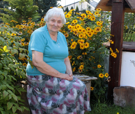 Zofia Bednarek, jedna z właścicielek ogrodu, przy starej studni, która stanowi dziś element dekoracyjny ogrodu